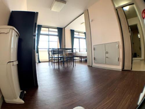 a living room with a table and chairs and a refrigerator at Big stone tsukuda / Vacation STAY 5836 in Aomori