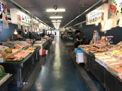 a fish market with people standing in the aisle at Big stone tsukuda / Vacation STAY 5836 in Aomori
