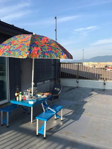 a table and chairs under an umbrella on a roof at Big stone tsukuda / Vacation STAY 5836 in Aomori