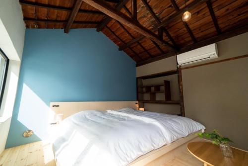 a bedroom with a white bed and a blue wall at Ebisuya / Vacation STAY 5851 in Kofu