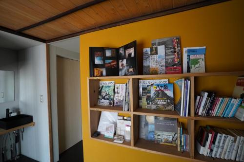 a book shelf filled with books on a yellow wall at Ebisuya / Vacation STAY 5851 in Kofu