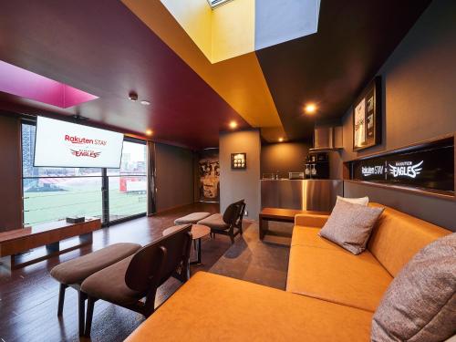 a waiting room with a couch and chairs and a television at Rakuten STAY x EAGLES 202 with Roof balcony in Sendai