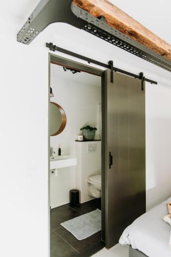 a bathroom with a sliding door with a toilet at Bed and Breakfast Pakhuis Maassluis in Maassluis