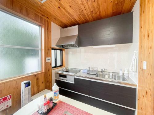a kitchen with a sink and a stove and a window at SYUkuhaku matuenosato / Vacation STAY 65782 in Matsue