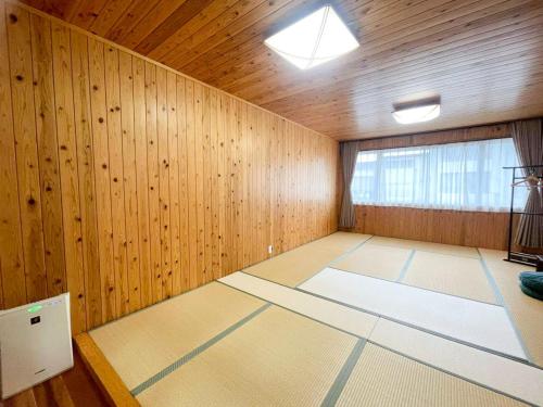 a large room with wooden walls and a large window at SYUkuhaku matuenosato / Vacation STAY 65782 in Matsue