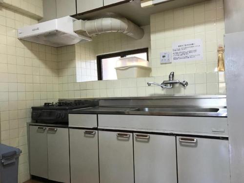 a kitchen with a sink and a stove in it at Weekly Harbourview Mansion Main Building / Vacation STAY 74570 in Naha