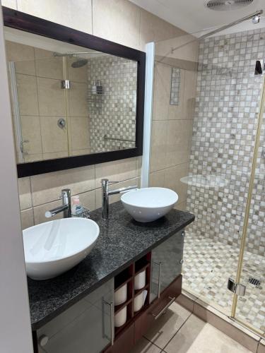 a bathroom with two sinks and a shower at Nautica flat 401 in Mossel Bay