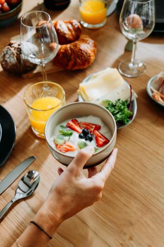 a person holding a bowl of food on a table at Bed and Breakfast Pakhuis Maassluis in Maassluis