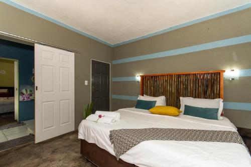 a bedroom with two beds with blue and gray walls at Woodpecker's Guest House in Hazyview