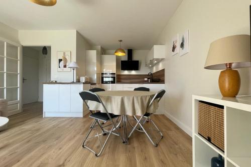 a kitchen and dining room with a table and chairs at The ammonite sea view with large balcony in Bénerville-sur-Mer