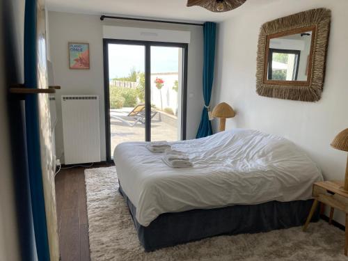 a bedroom with a bed and a mirror and a door at Les portes du golf Wimereux - Face mer in Wimereux