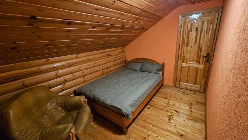 a bedroom with a bed and a chair in a room at Pilsētas rezidence in Jēkabpils