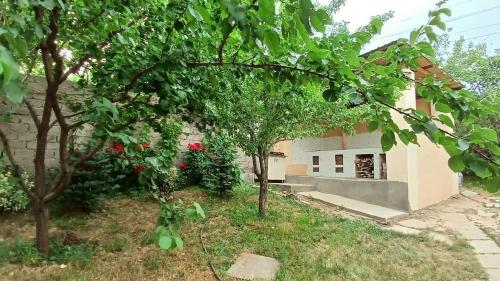 a house with trees in front of a building at Dacha in Yusufkhona