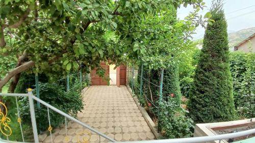 a walkway with a red door in a garden at Dacha in Yusufkhona