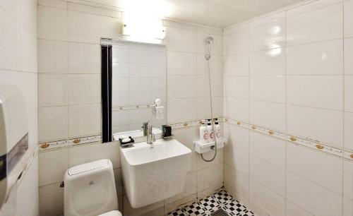 a white bathroom with a toilet and a sink at 필링모텔 스테이 
