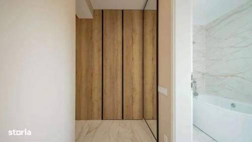 baño con puerta de madera y bañera en Art Partment 2, en Brasov