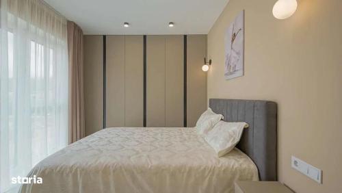 un dormitorio con una cama y una ventana en Art Partment 2, en Brasov