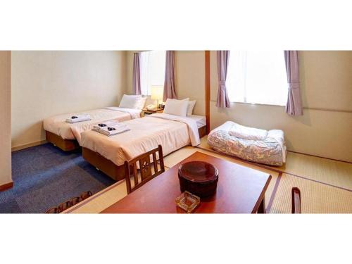 a hotel room with two beds and a table at Okinawa Sunplaza Hotel in Naha