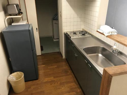 a kitchen with a sink and a stove and a sink at Weekly Harbourview Mansion Main Building / Vacation STAY 74567 in Naha