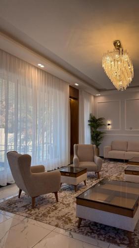 a living room with couches and a chandelier at جوهرة الرستاق السياحية in Far‘