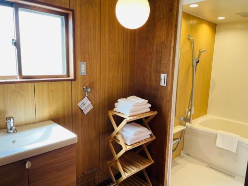 a bathroom with a sink and a tub and towels at ＡＴＴＡ ＨＯＴＥＬ ＫＡＭＡＫＵＲＡ - Vacation STAY 33593v in Kamakura