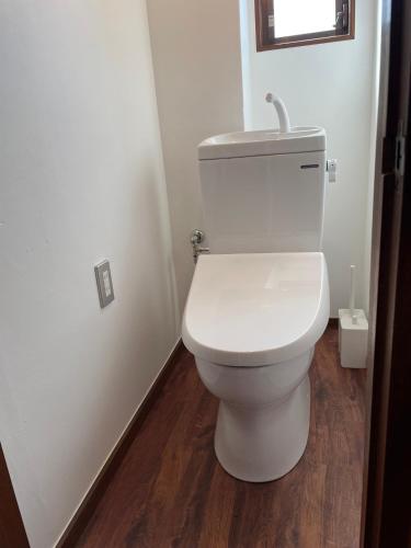 a white toilet in a bathroom with a wooden floor at ＡＴＴＡ ＨＯＴＥＬ ＫＡＭＡＫＵＲＡ - Vacation STAY 33593v in Kamakura
