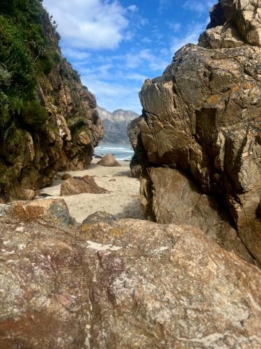a beach with rocks and the ocean in the background at Seaview on 2822 Happy Whale Cottage in Bettyʼs Bay