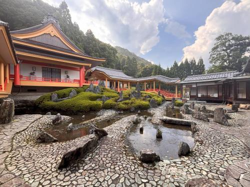 a temple with a pond in front of a building at HOTEL ARROWS Arashiyama in Kyoto