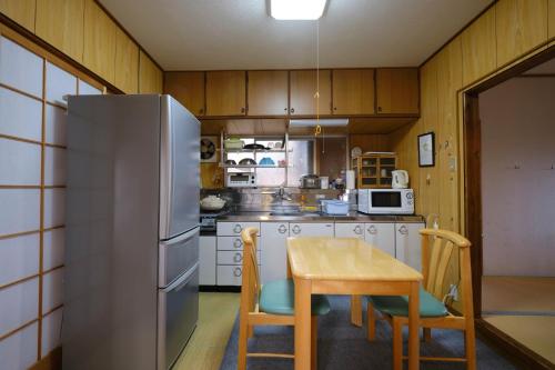 a kitchen with a table and a stainless steel refrigerator at Ichiya no jikka / Vacation STAY 78859 in Shimosato