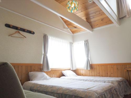 Dos camas en una habitación con ventana. en olive no sato vingh four eyes shodoshima / Vacation STAY 79057, en Kusakabe