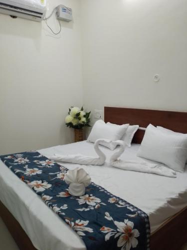 a bed with white sheets and flowers on it at Harigarh Inn in Alīgarh