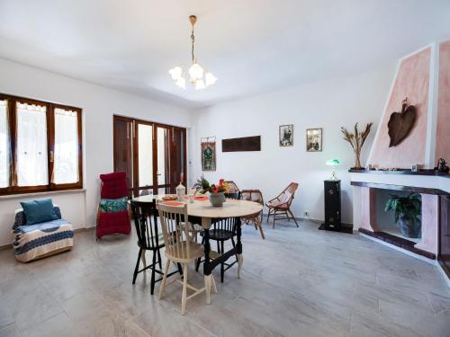 a living room with a table and chairs and a fireplace at Beachfront Villa with Solarium in Siniscola