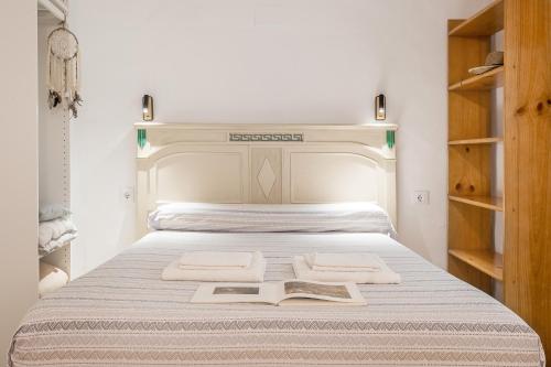 a bed with two towels and a book on it at Alicia's House in Granada