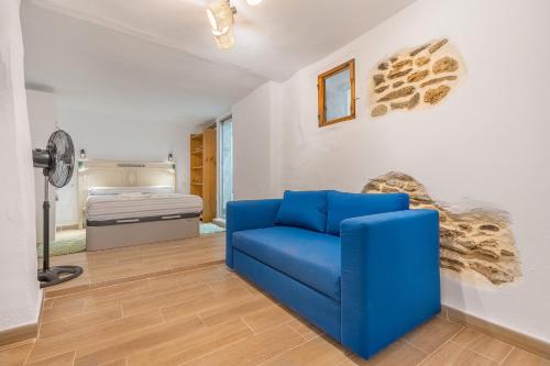 a blue chair in a room with a bed at Alicia's House in Granada