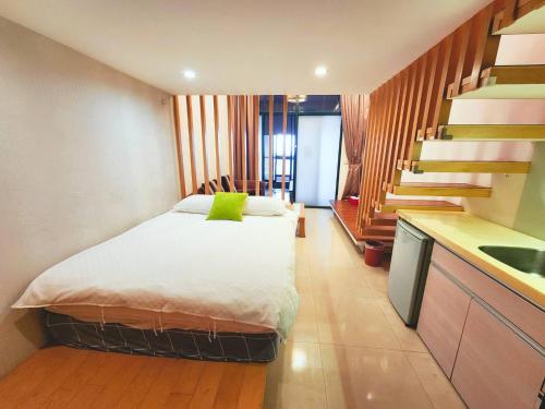 a small bedroom with a bed and a kitchen at 湯韻溫泉 in Jiaoxi