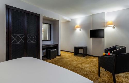 a hotel room with a bed and a television at Razana Hotel Al Jubail in Al Jubayl