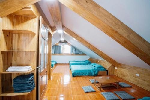 a attic room with two beds and a table at Truong Casa in Tam Ðảo