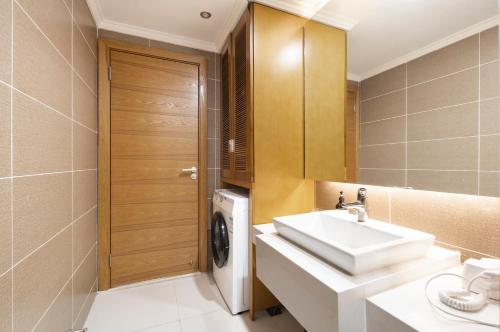 a bathroom with a sink and a washing machine at Chongqing Forest Design B&B in Chongqing