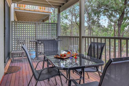 a patio with a table and chairs on a deck at Private 1bdr Villa Pinot located within Cypress Lakes Resort in Pokolbin