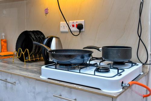 two pots on top of a stove in a kitchen at Qwetu Luxelite Studio With Rooftop Pool in Nairobi