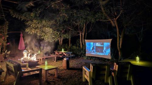 a fire pit and a television in a yard at night at The River in Jinja