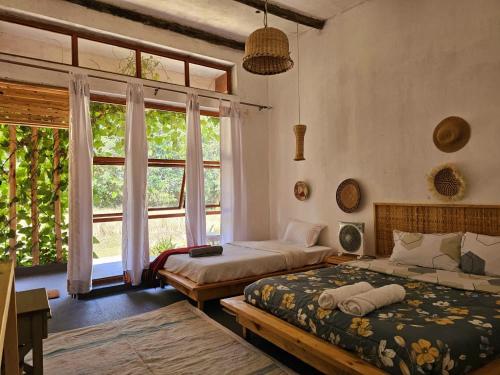 a bedroom with two beds and a large window at The River in Jinja