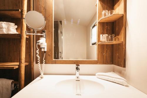 a bathroom with a sink and a mirror at Naturel Hoteldorf Schönleitn in Latschach ober dem Faakersee