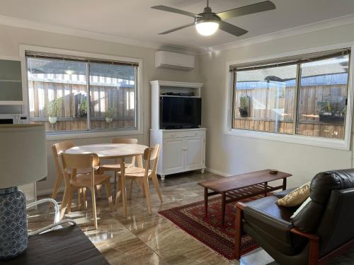 ein Wohnzimmer mit Tisch und Couch in der Unterkunft Patonga Street Retreat in Patonga