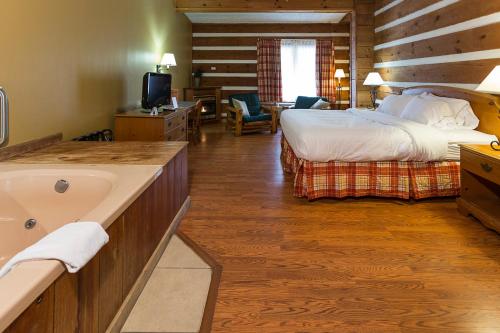 a hotel room with a bed and a sink and a tub at Timbers Lodge in Pigeon Forge