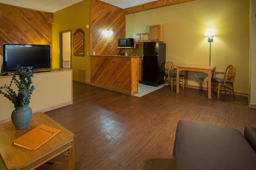 a living room with a couch and a table and a kitchen at Timbers Lodge in Pigeon Forge