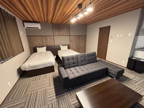 a living room with two beds and a couch at 又楽坊 Matarakubou in Fujiyoshida