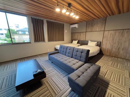 a bedroom with a bed and a couch and a table at 又楽坊 Matarakubou in Fujiyoshida