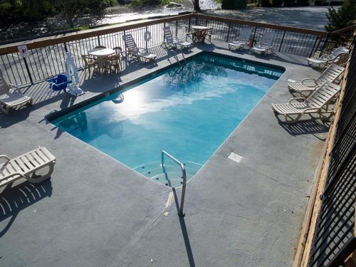 a large swimming pool with chairs and a table at Timbers Lodge in Pigeon Forge