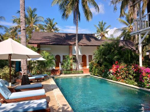 une piscine devant une villa dans l'établissement White Coconut Resort, à Gili Trawangan